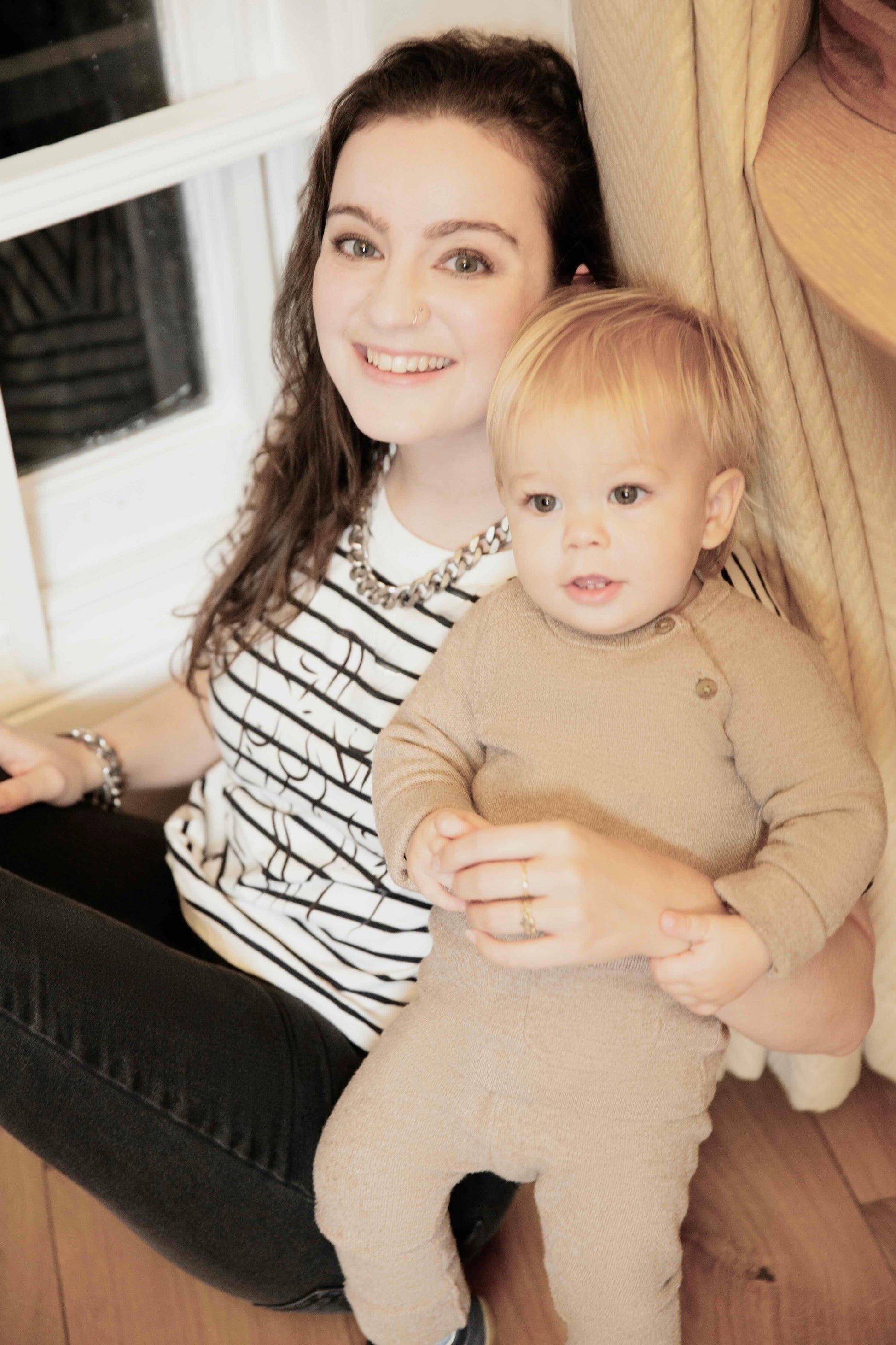 Woman wearing a Human Milk T-shirt holding her baby indoors