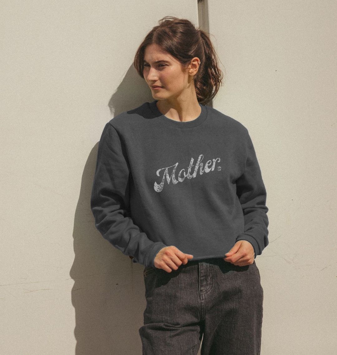 A woman wearing a Human Milk grey cropped sweater, easy to breastfeed in