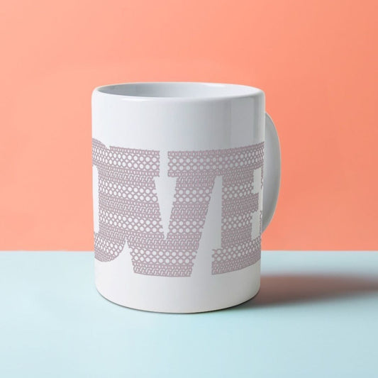 A white ceramic mug with the word LOVE on it, composed of a pattern made with the word BOOB.