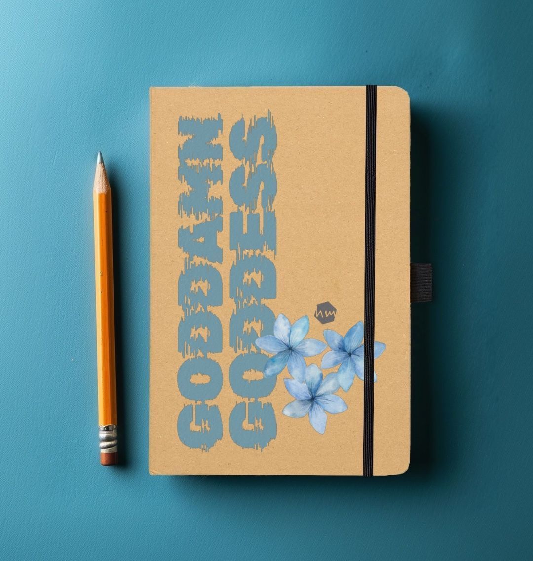 A notebook with the words Goddamn Goddess on it, with blue lilies